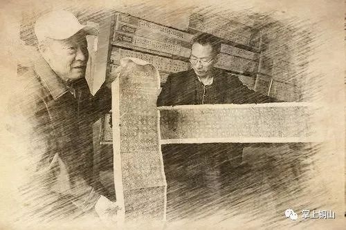 父子俩展示碑文拓片。.jpg 图片